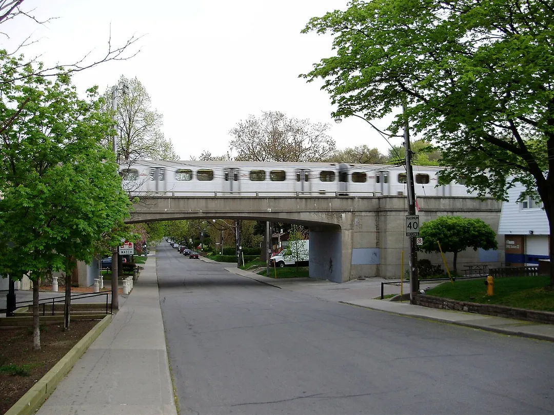 A subway train crosses above Clendennan Avenue, a residential road in the Toronto neighbourhood of High Park North.