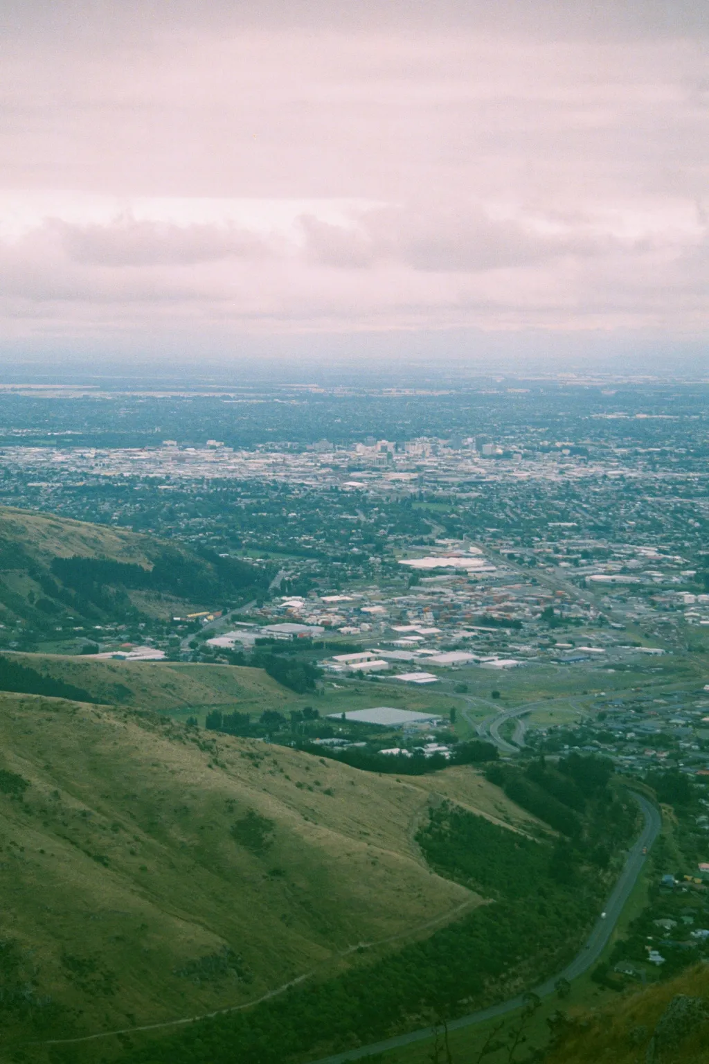 Christchurch, New Zealand, taken from the top of the gondola on the Port Hills.  Heathecote Valley is at the bottom right, and the municipalities of Woolston and Hillsborough are between Christchurch and the slopes of the hills.  The main road at the bottom is State Highway 74, which goes through the Lyttelton Harbor Tunnel (the entrance of which is just below and to the left of the photo).