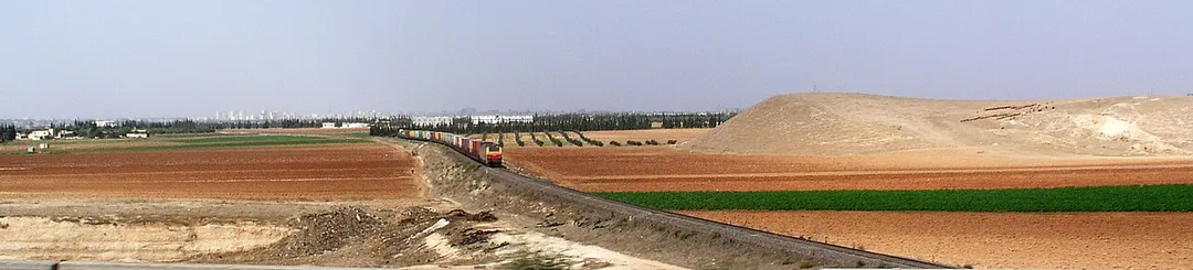 Train passing near a tell in the plain of Homs, Syria.