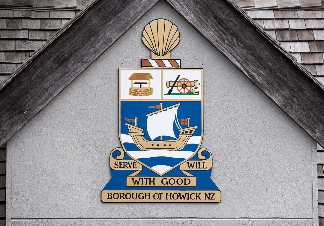 The coat of arms of the Borough of Howick (1952- 1989) on the gable of Howick Village Bus Shelter, Howick, Auckland. It displays the motto "Serve with good will".
