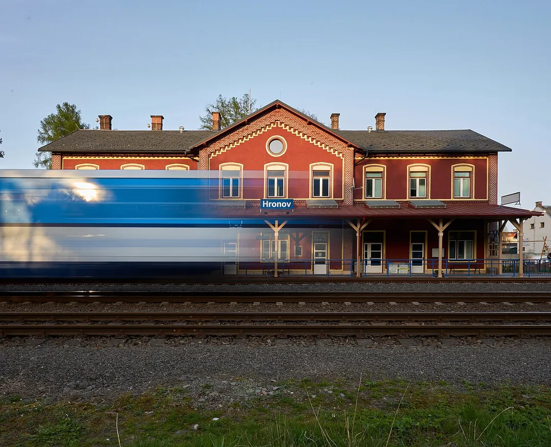 Evening photo of Hronov train station, 2024, České dráhy train moving in front of the station.