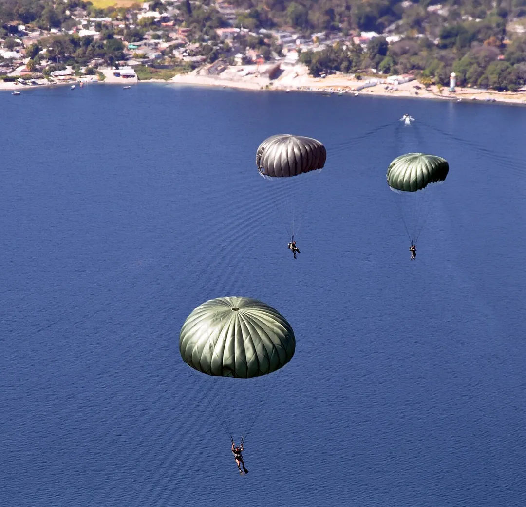 U.S. Soldiers with the 7th Special Forces Group and Salvadoran service members maneuver after jumping from the ramp of a U.S. Army CH-47 Chinook helicopter during a joint airborne operations training exercise over Lake Ilopango, El Salvador, Jan. 21, 2014. The training allowed service members from both nations to maintain currency while strengthening the relationship between the forces. (DoD photo by Capt. Zach Anderson, U.S. Air Force/Released)