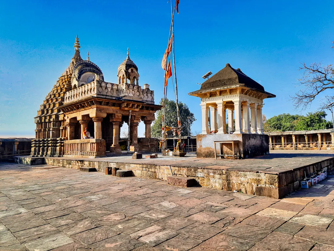 The Chausath Yogini temple of Bhedaghat is on a hill top about 20 kilometers west of Jabalpur, near Narmada river waterfalls. It is one of the famed circular temples of Shaktism (goddess tradition) in India. The temple is notable for 81 statues mostly from the 1st millennium Hindu traditions: some from 2nd-century Kushana period, some Gupta and post-Gupta centuries through the 12th-century. Most are severely mutilated, many beheaded or defaced with limbs broken and lost. Yet, whatever remains of the historic yogini statues is much more than several other yogini temples in Madhya Pradesh and Uttar Pradesh where merely structural ruins survive. The broken statues on display, elegantly produced in the 1st millennium, are impressive. This temple is best studied in comparison to Mitaoli/Mitawali yogini temple (Morena, MP) and the two Odisha yogini temples, in particular the Hirapur site (near Bhubaneswar, OD).
The Bhedaghat site was brought to the western attention by colonial era archaeologists. They took and published photographs of the site in the 19th-century. These photographs show a badly damaged site, fallen ruins, broken statues, scattered artwork and temple parts. The site was restored and rebuilt in the 20th century, and the 81 statues found were then placed in 81 niches of the circular temple, not necessarily in the original 10th-century order. The statues on display include the 64 yoginis and 17 more. These now have inscribed name labels added to help tourists, but these names and their sequence do not correspond to the standard 64 yoginis list found in historic Sanskrit texts of Hinduism.
During the restoration work, limited excavation revealed that the site had a Hindu goddess tradition temple by the 7th century, which itself replaced something from pre-6th century structure with Kushana era artwork. The first circular hypaethral temple here was built in the 10th century.

The extant temple remains a hypaethral structure, with a Gauri-Shankar (Parvati-Shiva) temple in the center.