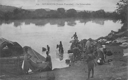 People and boats gathered at the edge of the Niger River at Kouroussa, in what is today Guinea.  French postcard, published c 1911, while under French Colonial Rule