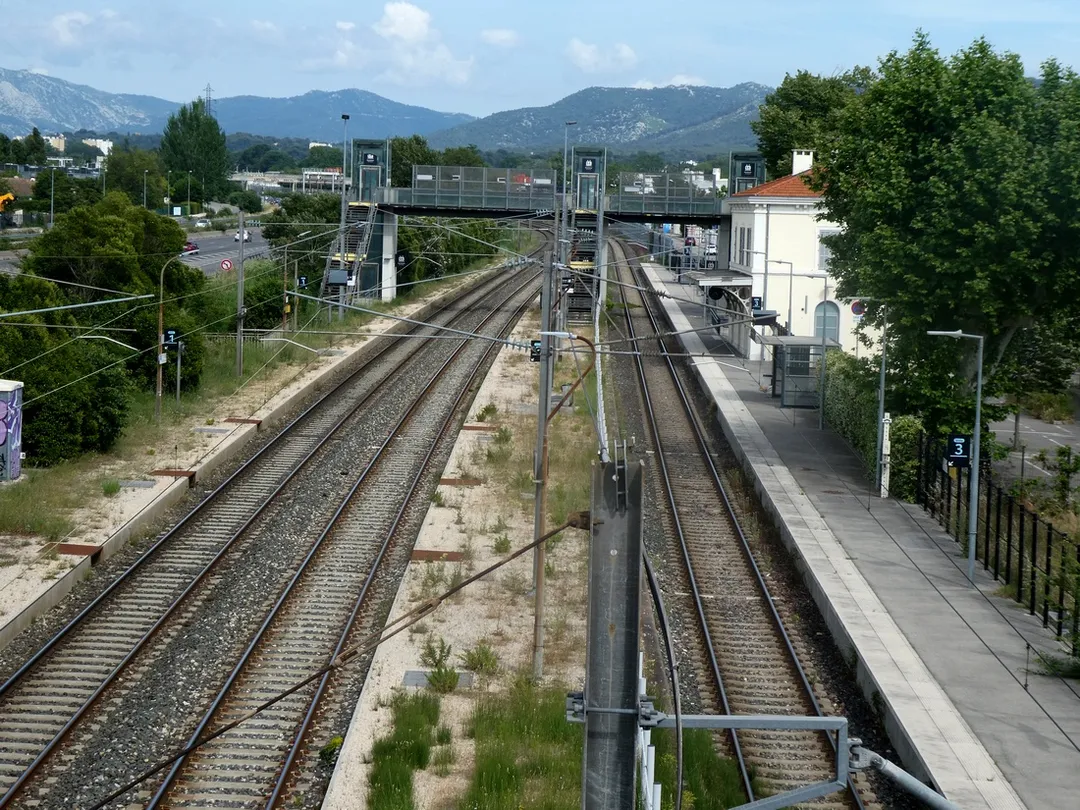 Gare de la Penne-sur-Huveaune. La voie de droite est affectée au trafic local entre Marseille-St-Charles et Aubagne (voie unique à circulations alternées), les deux voies de gauche au trafic express Marseille - Toulon.