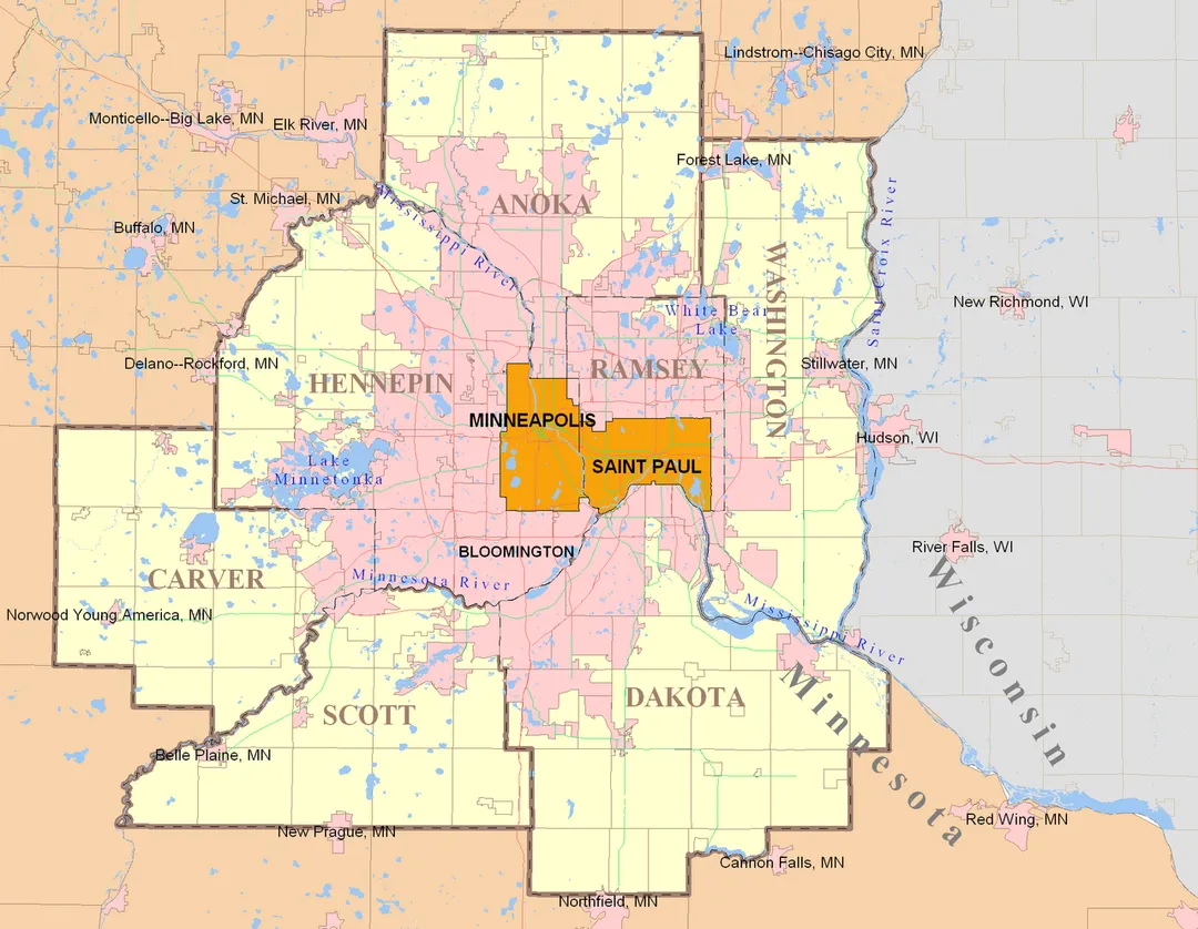Twin Cities 7-County Metropolitan Area with labels. The grey shaded portion is Wisconsin. Note this 7-County definition is outdated by the expanded 11-County metro map which includes counties in Wisconsin (search Commons for it). The U.S. Census Bureau sets these definitions which were adopted by the regional government (Metropolitan Council). 
This map has some slight errors. All pink areas are "urbanized areas" meaning serviced by some wastewater agency and not zoned rural. However only the contiguous pink area stretching from the two core cities of Minneapolis and Saint Paul are considered part of the metropolitan Twin Cities which are both defined by law and by cultural consciousness. This contiguous urban area is called the Metro Urban Service Area boundary (MUSA) as defined by the Metropolitan Council, the regional government. The regional wastewater system allows high-density development. Some of the outer cities (small towns) are connected to the the regional system noted by the updated 11-County map. 
Other lines: The greyish grid-like lines are municipal boundaries of the many suburbs surrounding the core cities of MSP.  As you can see some suburbs have non-urbanized areas. The light red lines that seem to weave the inner area of the pink is the interstate highway system, which is now eclipsed by an expanding urban area. The urbanized area answers to the Met Council and not the core cities of Mpls or StP. As you can see, the ratio of actual core city area is very low. 

Map is produced via MapInfo Professional using only publicly available data from government agencies.