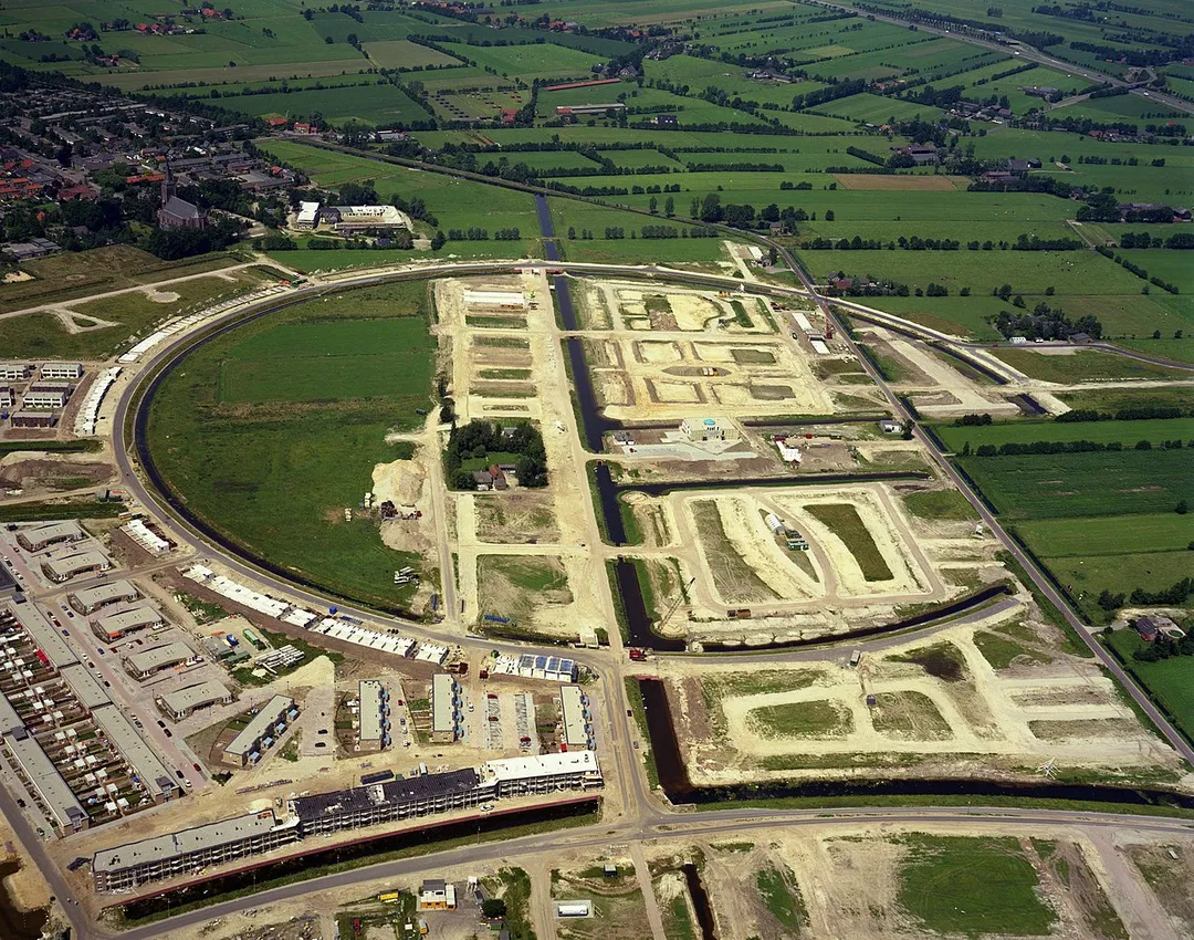 Luchtfoto van het centrale gedeelte van de in aanleg zijnde wijk Kattenbroek te Amersfoort uit het zuidoosten; met op de achtergrond een gedeelte van de wijk Langenoord te Hoogland (gemeente Amersfoort).  
Het Utrechts Archief, Catalogusnummer 50022