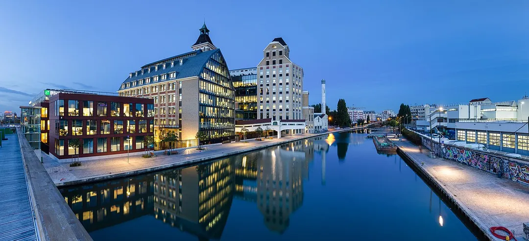 Pantin Mills, and canal of Ourcq, in Pantin, Seine-Saint-Denis, France. Renovated in the years 2000s, Pantin Mills now serve as offices and headquarters for BNP Paribas Securities Services. This picture is a mosaic of 13 pictures each taken at 21mm, f/8.0, 3.5 sec and ISO 100, with a Canon 7D + Canon 17-55 f/2.8 mounted on. Stitching itself was done with Hugin. Resulting horizontal FOV is 164°.