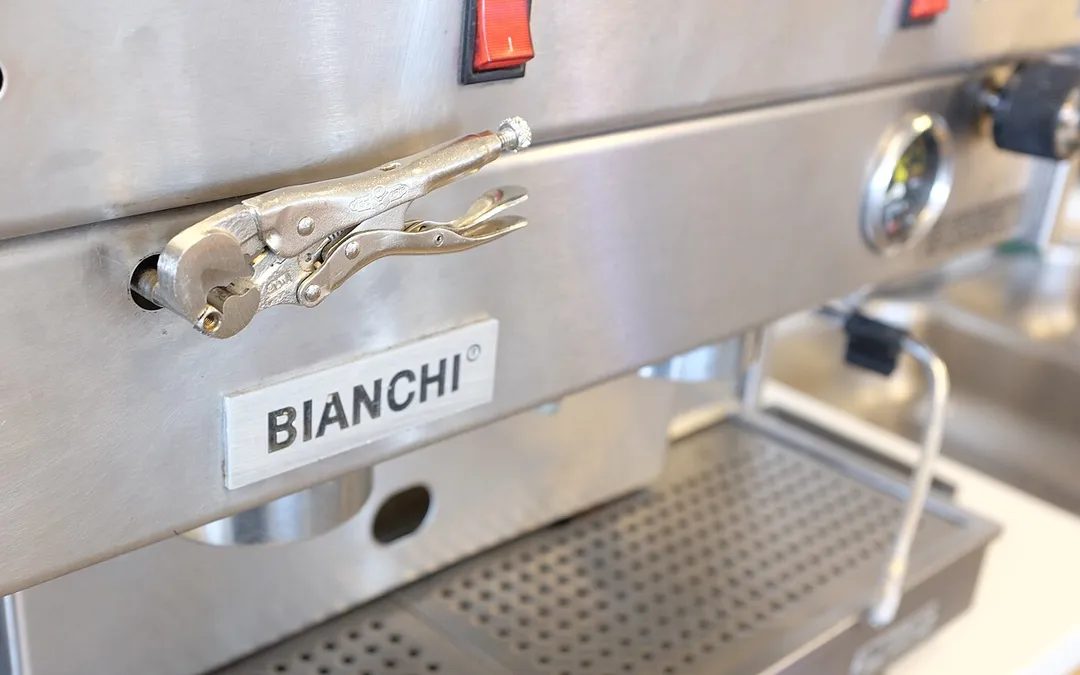 Locking pliers being misused as a knob on an espresso machine.