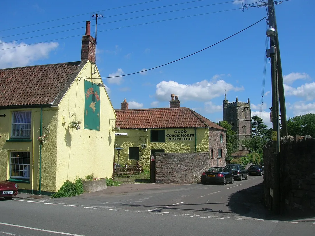 Junction of Long Ashton Road and Church Lane, Long Ashton, Somerset. On the left is the Angel Inn. On the right is the tower of All Saints parish church.