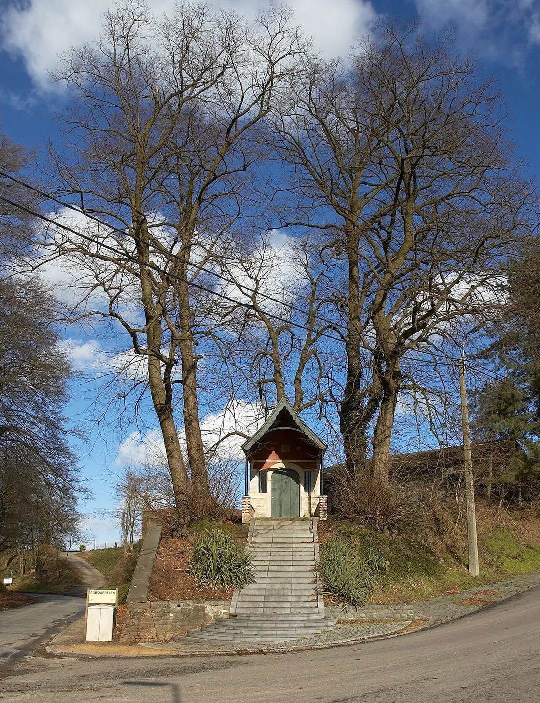 Rochuskapel te Huldenberg, België, kjkend richting noord-oost. Ter gelegenheid van de restauratie in 1919 werd boven de ingang een luifel bijgebouwd. Zie ook


		
			
			Jaartallen boven de deur
		
		
			
			Uitzicht vanaf de deur