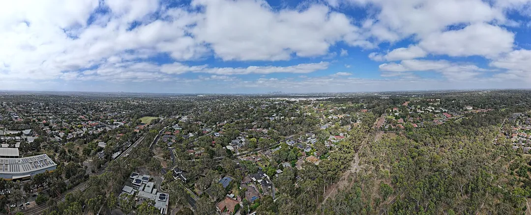 Aerial panorama of Macleod facing west towards the Melbourne skyline. February 2024.
