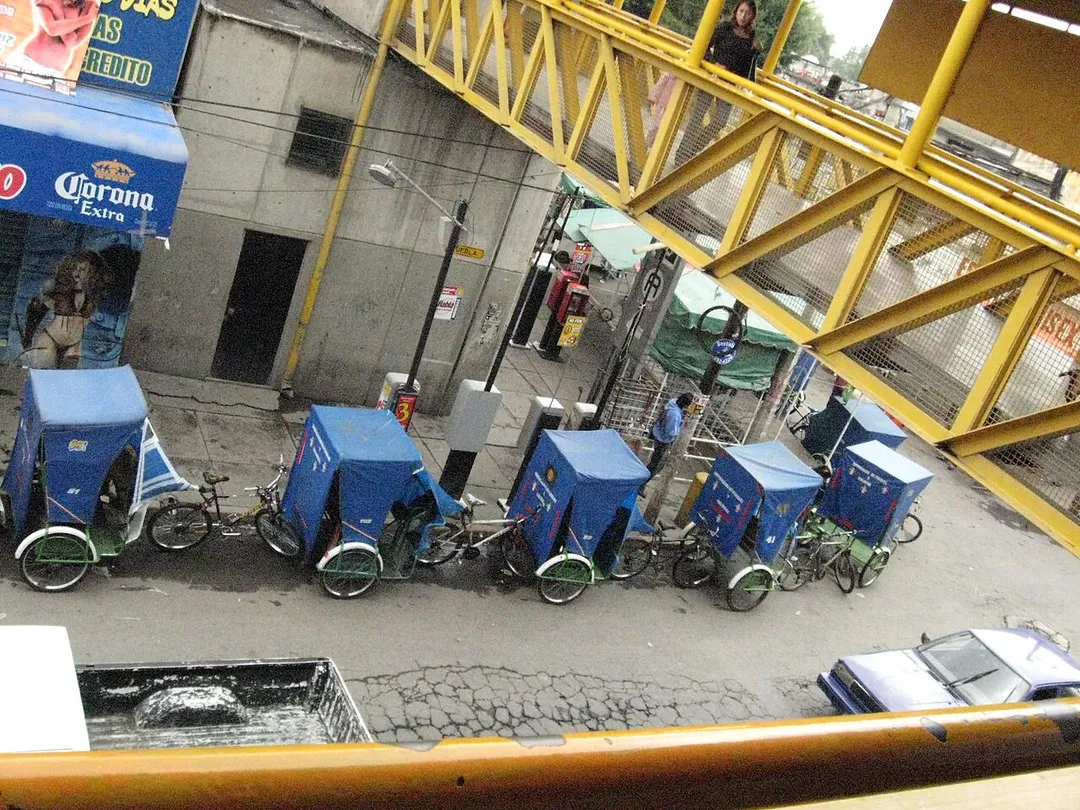 A line of bicycle taxis waiting for business on Horacio Zuñiga Street in Los Reyes Acaquipan, Mexico just outside the Metro Los Reyes station