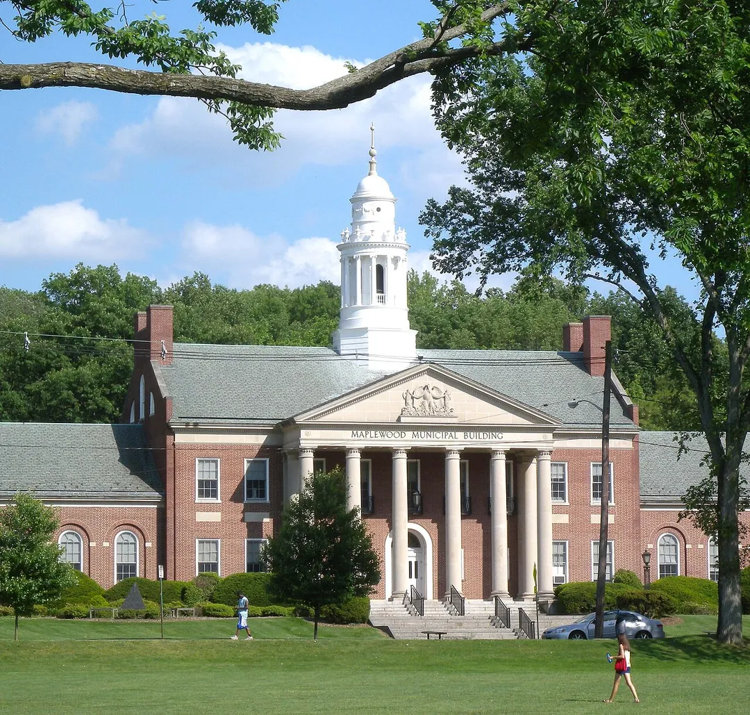Looking southeast, full zoom, far across a lawn at en:Maplewood, New Jersey Municipal Building on a mostly sunny early afternoon.