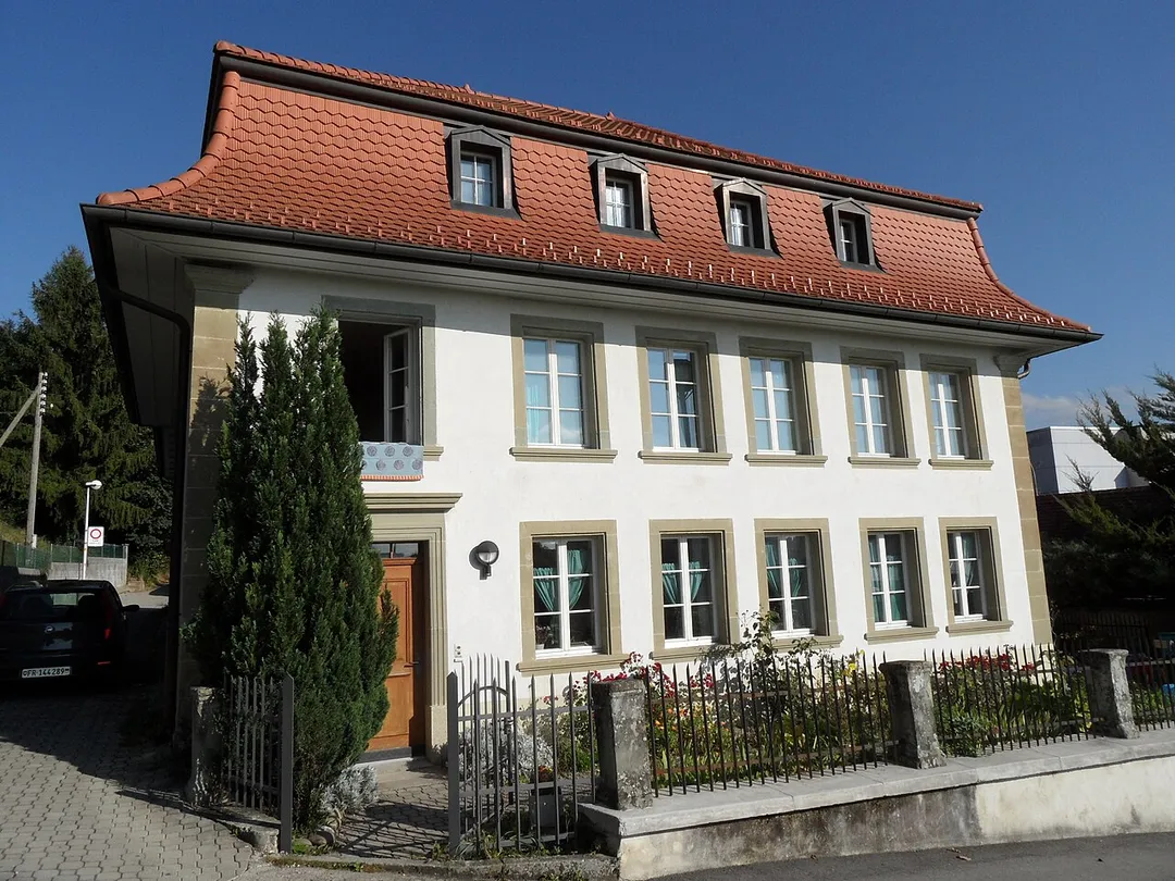 Maison patricienne avec toit mansardé à Marly, canton de Fribourg en Suisse.