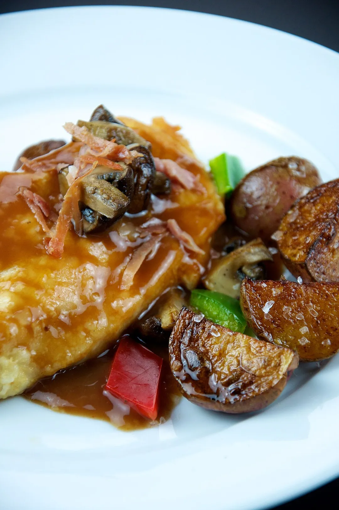 Chicken marsala made with quartered Cremini mushrooms, red potatoes, red and green bell peppers, and pancetta. Photographed in the Upper Dimond neighborhood of Oakland, California, USA.