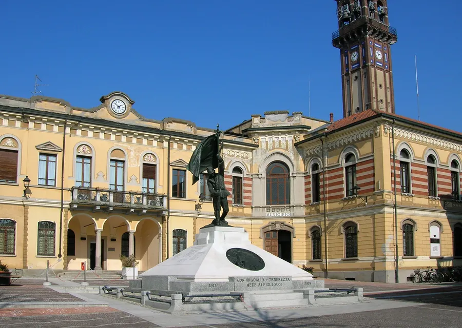 Il monumento ai caduti di fonte al municipio di Mede. Alle spalle l'alto campanile della parrocchiale (63 metri)