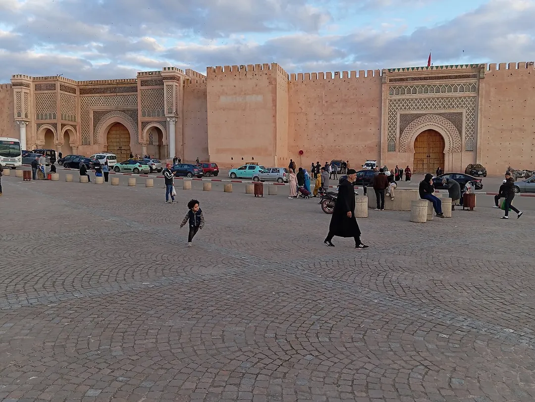Bab Mansour in Meknes.
Die Südostseite des Platzes El Hedim wird vom Bab El Mansour, dem mächtigsten Tor der Stadt, beherrscht. Die dem Platz zugewandte Fassade des dreibogigen Tores, dessen Vollendung im Jahr 1732 zu verzeichnen ist, ist mit reichen Reliefs und Keramikfliesenverzierungen geschmückt. Aufgrund des prächtigen Schmucks wird das Tor, das vormals als Schauplatz öffentlicher Gerichtsverhandlungen und Hinrichtungen diente, häufig als das prächtigste des Landes bezeichnet. Es markiert den Zugang zur als "Ville impériale" bezeichneten Anlage.