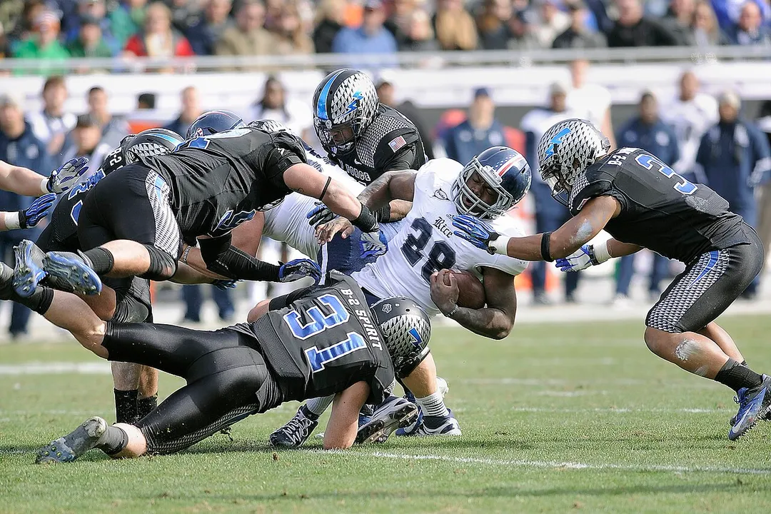 Charles Ross, center, a running back for Rice University, is dragged down by Falcon defenders with the U.S. Air Force Academy football team during the 2012 Armed Forces Bowl in Fort Worth, Texas, Dec. 29, 2012. Rice defeated Air Force, 33-14. (DoD photo by Sarah Chambers, U.S. Air Force/Released)