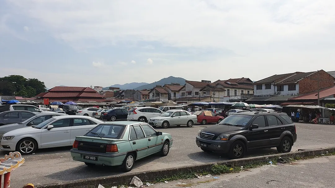 Cars parked adjacent to a key morning market, in Menglembu, Ipoh, Malaysia.