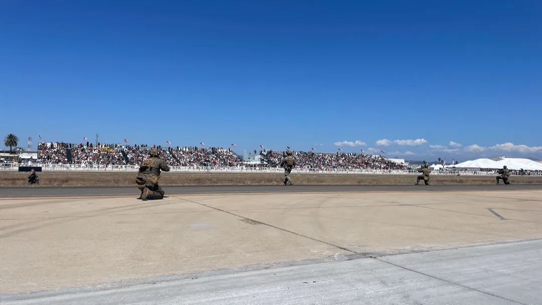 Marines of the 1st Marine Division demonstrate Marine Air Ground Task Force (MAGTF) tactics as they strategically move towards the thousands of spectators gathered on the apron at the 2026 Miramar Airshow.
