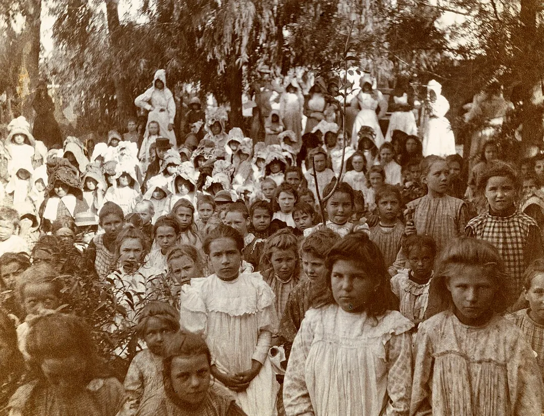 Large group of children at a cocoa party in Nylstroom Camp, c1901. Photograph inserted at page 86 of Millicent Garrett Fawcett's Report on the concentration camps in South Africa, by the Committee of Ladies appointed by the Secretary of State for War; containing reports on the camps in Natal, the Orange River Colony, and the Transvaal (1902).