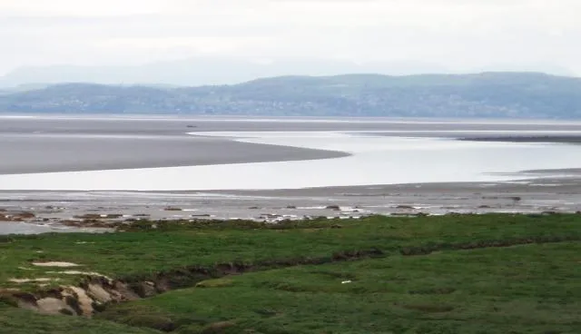 Looking across Morecambe Bay from Hest Bank towards Grange-over-Sands at low tide.