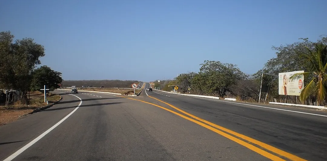 Rodovia federal BR-304 (à esquerda, saída para Fortaleza-CE) e rodovia estadual RN-013 (à direita, em linha reta) em Mossoró, Rio Grande do Norte, Brasil, saída para Tibau.