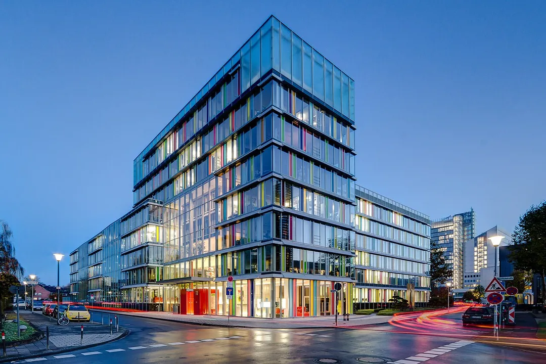 Office building (LVM 7 and 6) of the LVM Insurance in Münster, North Rhine-Westphalia, GermanyThe origins of today’s LVM campus date back to 1967, when the company moved into its premises on Kolde-Ring at the corner of Weseler Straße. The campus’s seven insurance buildings are located south of Münster city center. The northern part of Von-Stauffenberg-Straße runs through the campus, while Sperlichstraße forms its southern boundary. The LVM buildings were constructed between 1965 and 2014. The insurance company’s three high-rise buildings in particular are part of Münster’s skyline. The ground-level sculptures “Body and Soul” (Duk-Kyu Ryang, 2015) and “Two Horses for Münster” (Stephan Huber, 2002) are central visual elements of the site design. The 63-meter-high office tower LVM 5, known as “Crystal”, is a particularly striking building due to its design, while the 80-meter-high building LVM 3, known as “Tower”, is one of the tallest buildings in Münster.