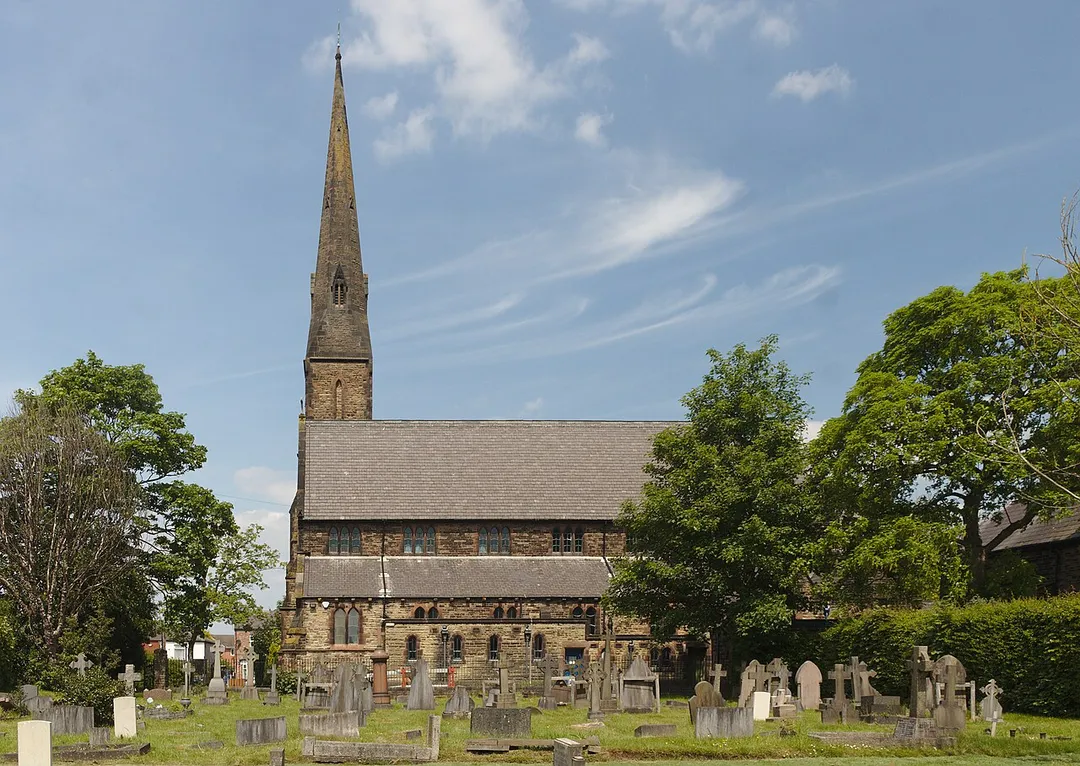 The south side of Grade II listed Ss Mary &amp; John church, Newton-le-Willows across the churchyard.