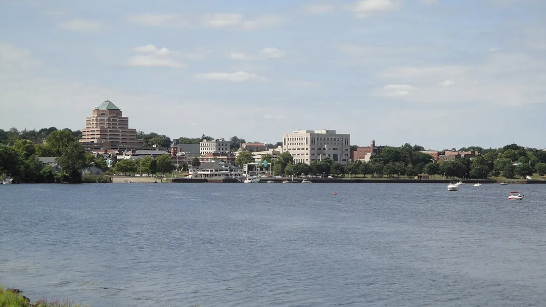 City of Middletown, Connecticut as seen from River Road, looking west/northwest along the major bend in the Connecticut River, showing Harbor Park and buildings along Main Street and downtown.