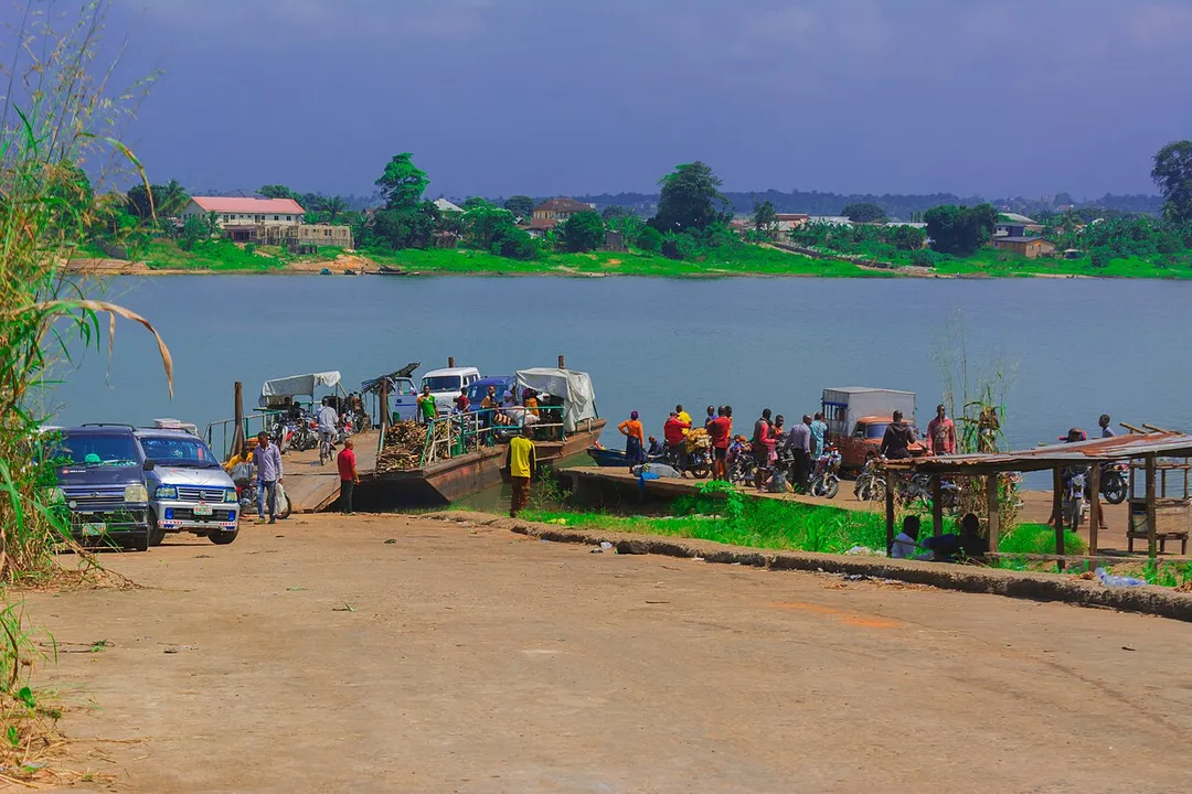 Bank of Oguta Lake showing human activities and rural dwellers. These includes motorcyclists,loaded pontoon and automobile drivers engaged in movement of goods, services and people.