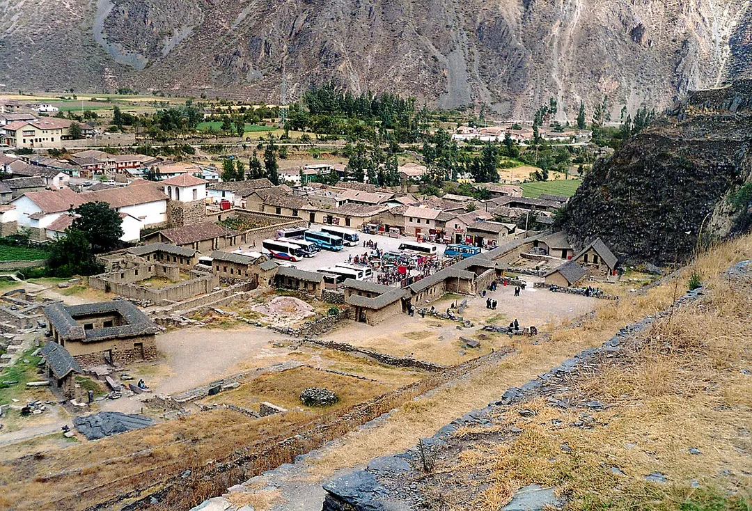 Ollantaytambo, Peru. The photo was taken in 2002 by Håkan Svensson (Xauxa). Note: As of 2025, the place where you see vehicles parked, is completely overrun by vendor stalls.
