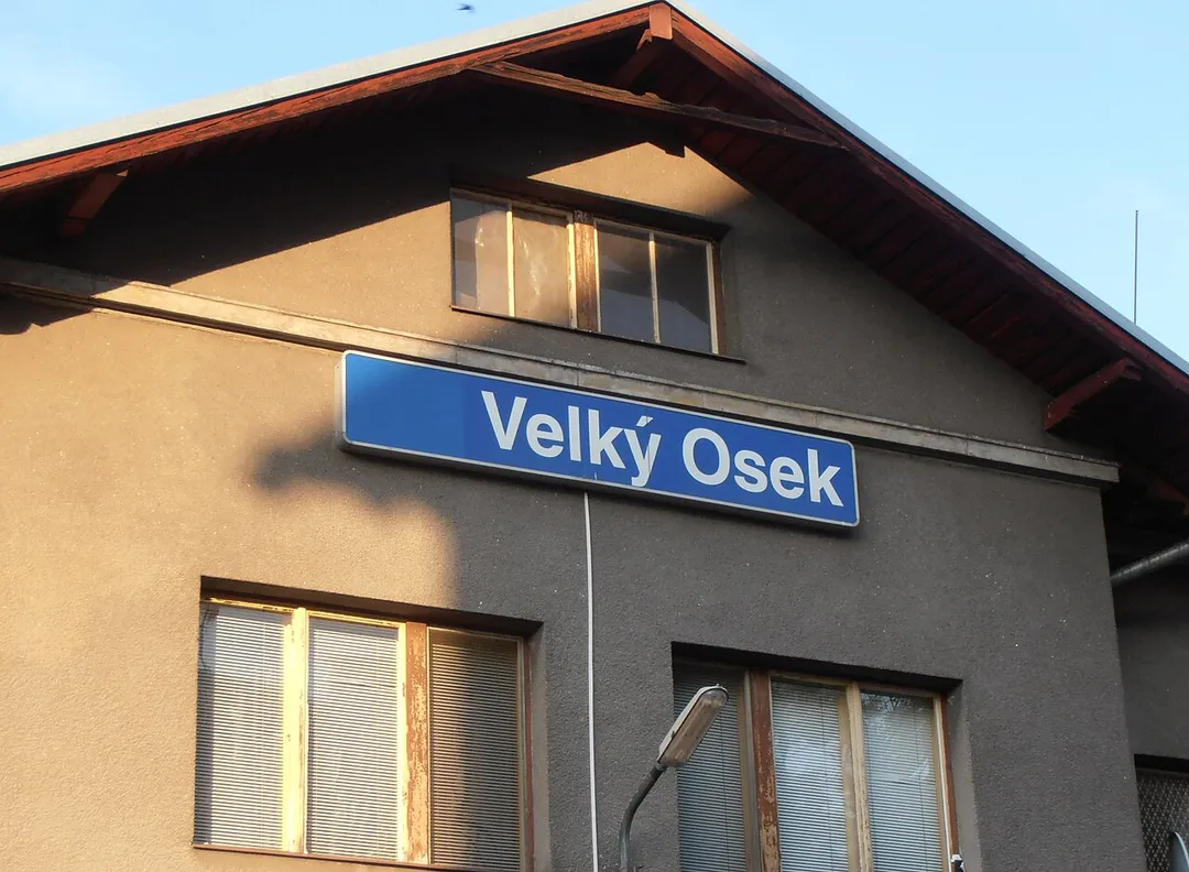 Tablica z nazwą stacji na budynku dworca Velký Osek.