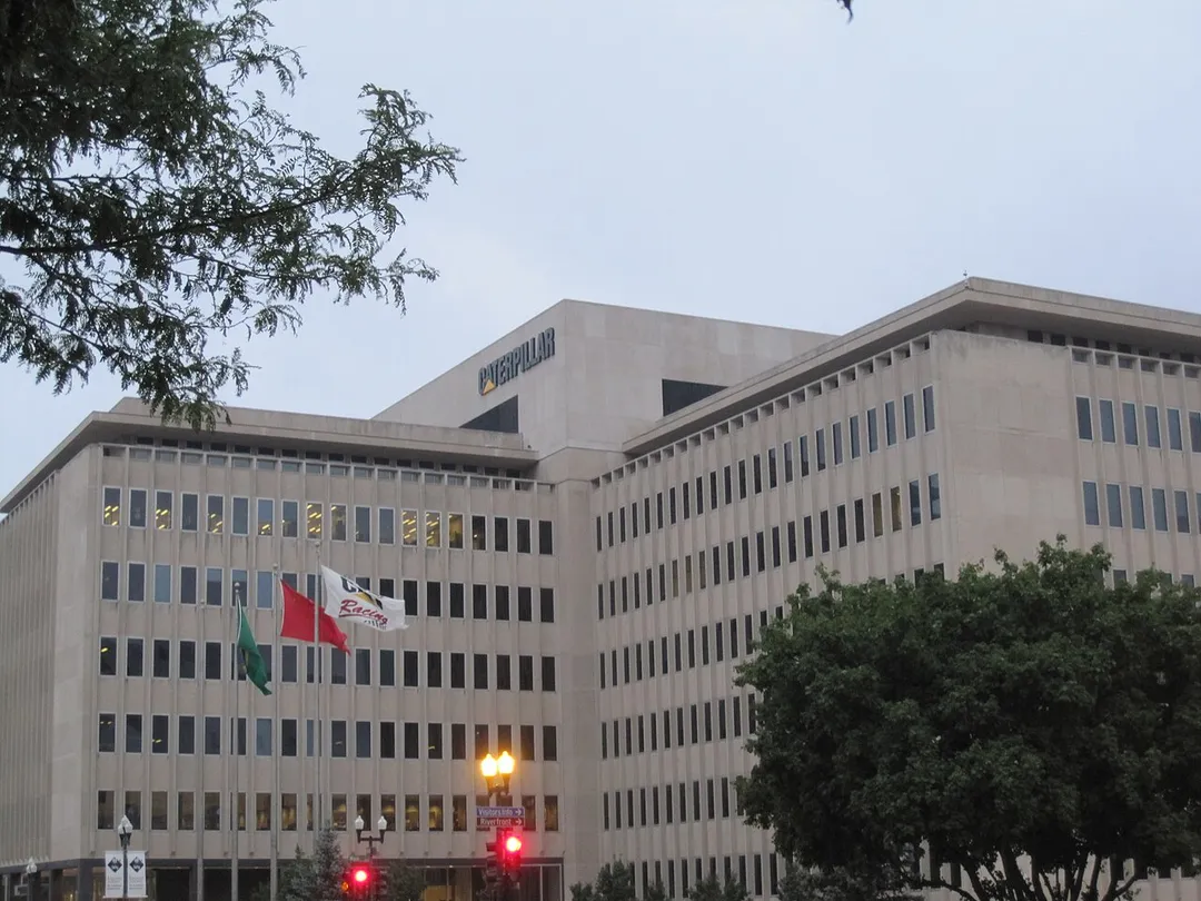 Caterpillar world headquarters (G.O. / building AB), east from corner of Adams Street and Main Street, downtown Peoria, Illinois, USA, August 2009.  Flags from front to back (right to left): Caterpillar Racing, People's Republic of China, and Brazil; the fourth flagpole (in line with window frames) has no flag.