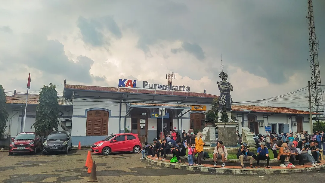 Main building of Purwakarta Station, with a statue in front of it