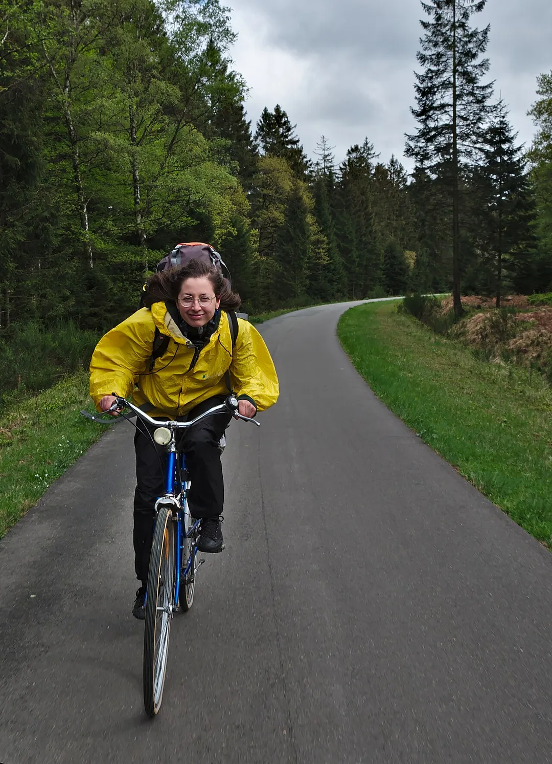 Yellow cyclist bicycling down the Vennbahnweg in Raeren, Belgium