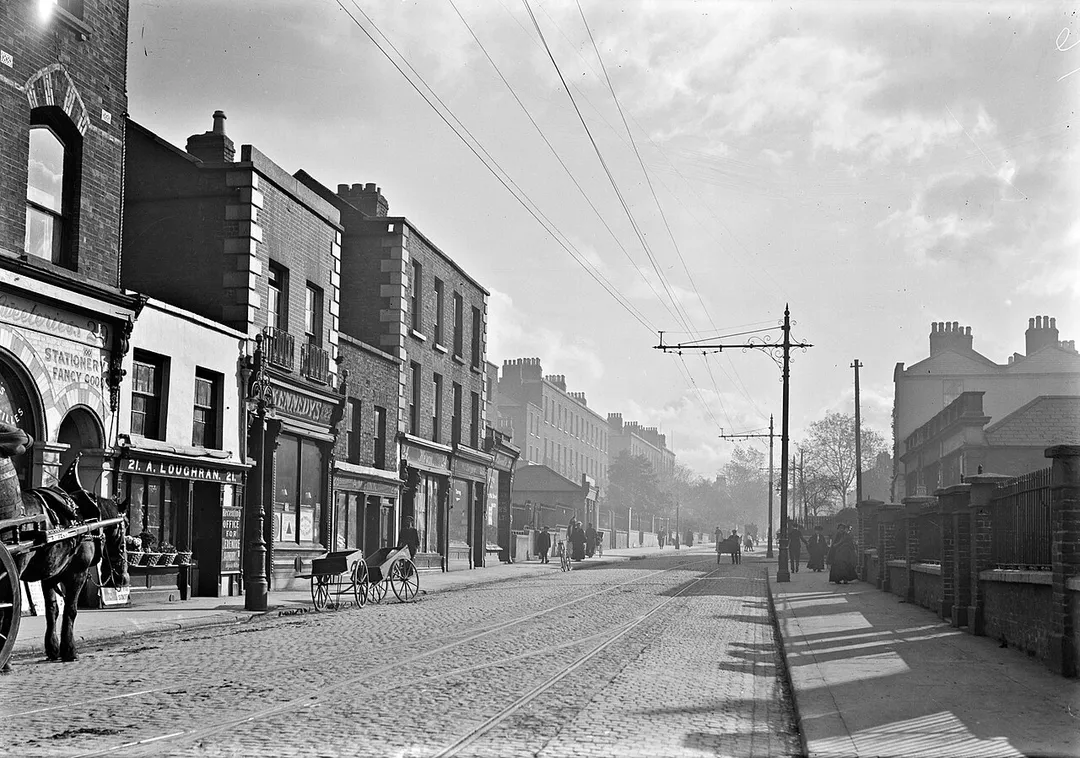 Todays offering from the vaults beneath Library Towers is much more identifiable than last Friday's offering. Rathmines Road Upper back in the day with tramlines, horse cart deliveries and cobbled road surface. Heaven!
While, unlike Friday's headscratcher, location and subject were largely known here, the date was not. Based on the businesses, tramlines and (partial) posters visible, the general consensus is that this image dates from around 1910-1911. Comparing the modern streetview, which captures similar businesses and business names (a laundry, Kennedy's, pub, etc) you'd perhaps be forgiven for thinking it was less than 100+ years ago....
Photographer: Unknown
Collection:  Eason Photographic Collection
Date: Catalogue range c.1900-1939. Possibly c.1910
NLI Ref:  EAS_1937

You can also view this image, and many thousands of others, on the NLI’s catalogue at catalogue.nli.ie