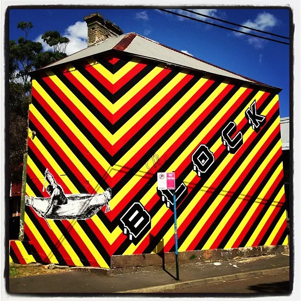 a large building with yellow, red and black street art
