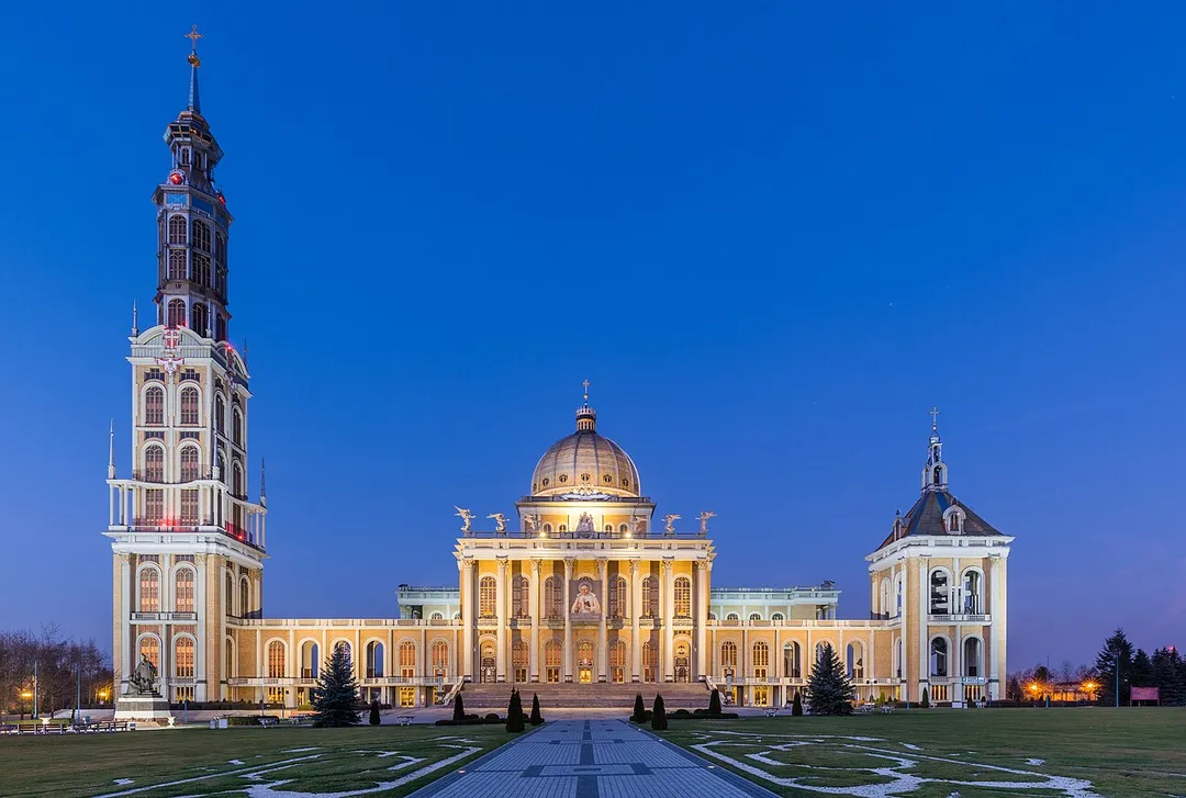 View at dusk of the Basilica of Our Lady of Sorrows, Queen of Poland, located in the village of Licheń Stary, near Konin, Greater Poland Voivodeship, Poland. The basilica, designed by Barbara Bielecka was built between 1994 and 2004. With a 120 metres (390 ft) long and 77 metres (253 ft) wide nave, a 98 metres (322 ft) high central dome, and a 141.5 metres (464 ft) high tower, it is Poland's largest church and one of the largest churches in the world.