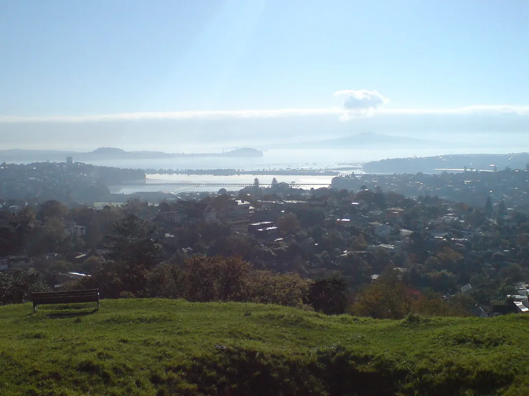 Hobson Bay in Auckland City, New Zealand, looking north from Mount Hobson. In the far distance to the right, Rangitoto Island can be seen. In the middle distance, Mount Victoria (left centre) and North Head (right centre) are visible. Hobson Bay is in the middle, divided from the Waitemata Harbour by Tamaki Drive. Near the front are Parnell in the west, western Remuera (close-by) and Orakei (far distance at the right, below Rangitoto).