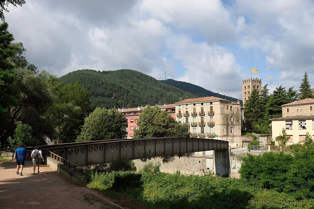 Footbridge in Ripoll Catalonia Spain
Deep in the scenic Catalan Pyrenees, as the wooded foothills and waving-in-the-breeze Catalan Senyera will suggest.  Ripoll is as pretty as it looks in this shot, and small; fewer than 11,000 call it home.