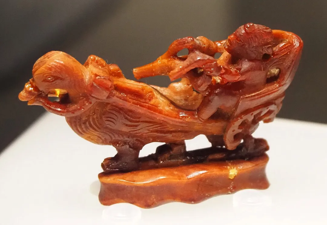 Amber figurine, one of the few extant creations of the “Master of the Aquileia Eros”, an anonymous artist. Discovered in Alburnus Maior - Necropolis of Pârâul Porcului / Tăul Secuilor (Roșia Montană, Alba county, Romania), 1st - 2nd century AD, Bucharest, National Museum of Romanian History (Inv. 358809). 
Photograph taken at the National Archaeological Museum of Madrid during the exhibition “Archaeological Treasures of Romania” (PDF catalog, p. 592).