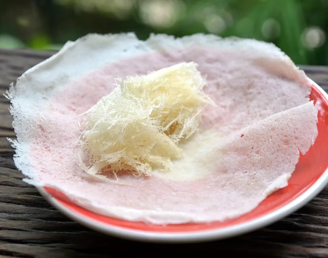 Roti sai mai (Thai script: โรตีสายไหม): small and thin pancakes used as a wrapper for a kind of candy floss/cotton candy. It is extremely sweet. The above image was made in Chiang Mai, Thailand. This image shows how the thin pancakes are made.