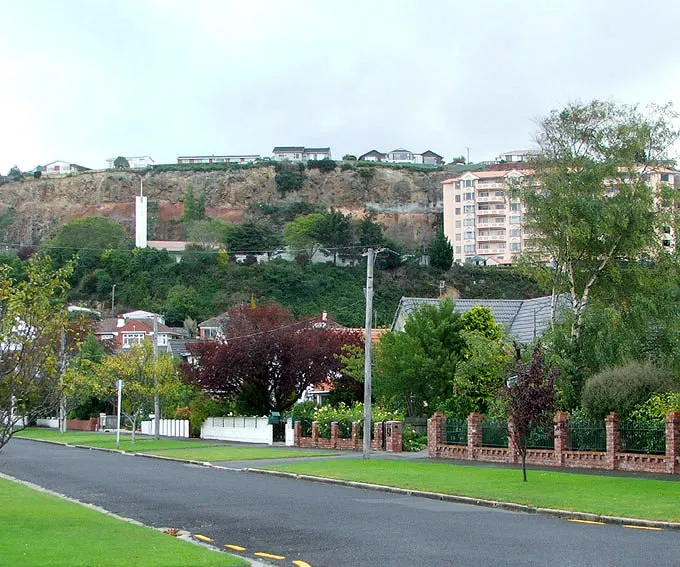 Forbury, Dunedin, New Zealand. The Frances Hodgkins Retirement Village and the spire of Dunedin's meetinghouse of The Church of Jesus Christ of Latter-day Saints are visible against the cliffs of the former quarry that lies to the west of Forbury Road. Photograph, taken from Wilson Avenue, by James Dignan (User: Grutness), March 9, 2009