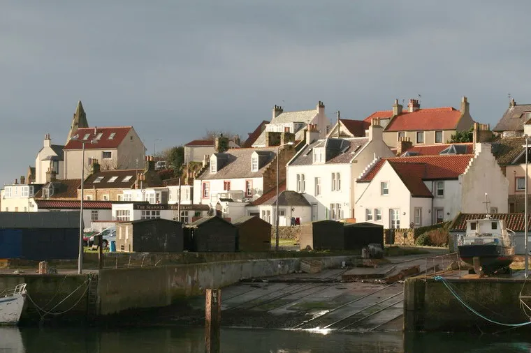 A view of the west end of St Monans harbour, with the spire of the church just visible behind the houses