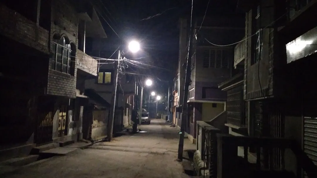 An empty narrow street at night in Sainthia.