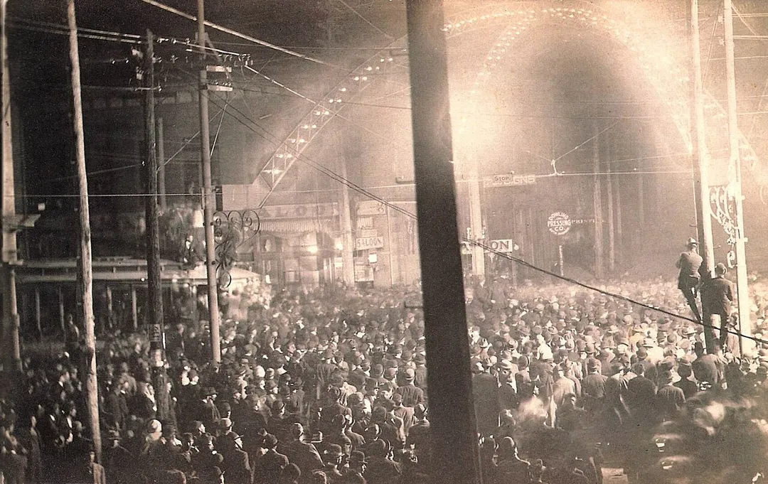 Commercial Avenue jammed with spectators below the electrically lit Hustler's Arch during the lynching of Will James, November 11, 1909, Cairo, Illinois.