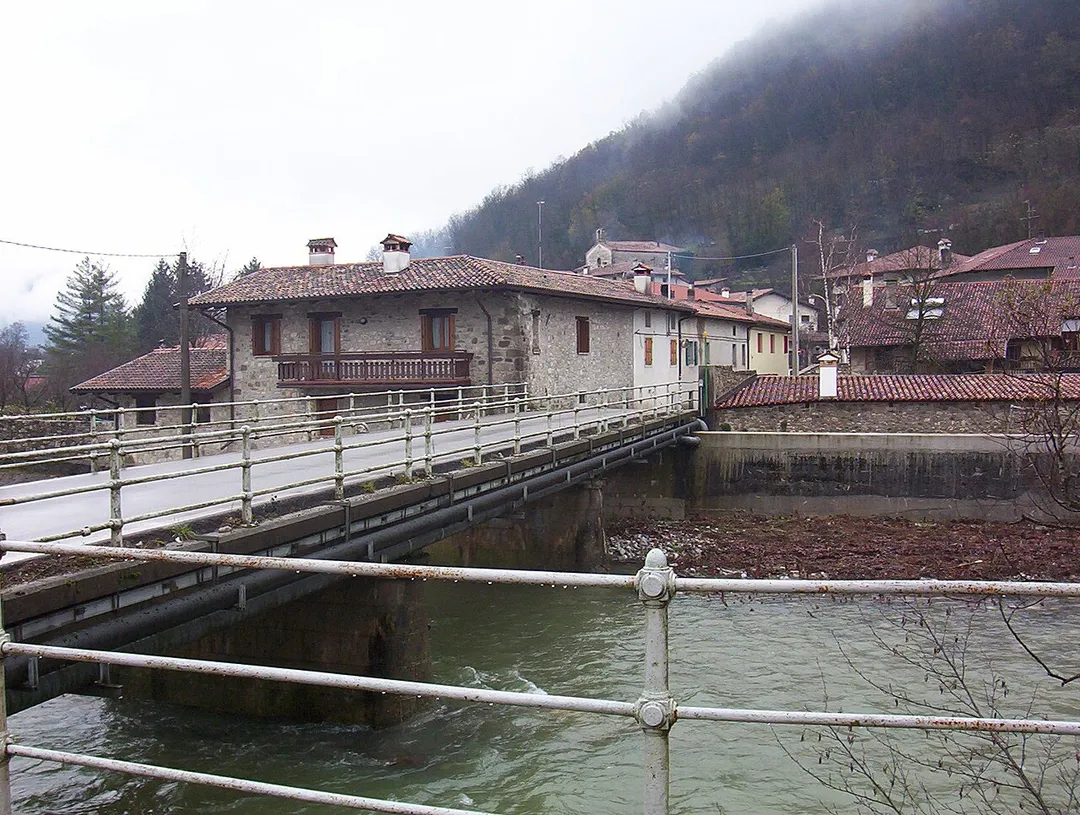 Il ponte sul fiume Cosizza tra Merso di Sopra e Scrutto. Il centro abitato sullo sfondo è Scrutto, una frazione del comune di San Leonardo (UD), Italia. L'immagine è una fotografia scattata da Trevirgola e risale all'autunno 2005.