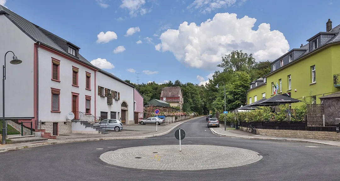 Street in Sandweiler-Gare, Luxembourg, as seen from the roundabout in front of the ancient train station.
